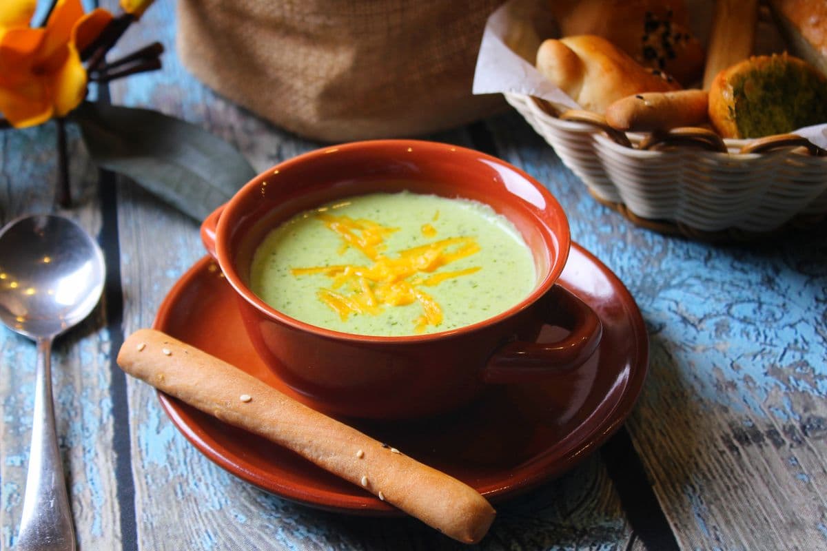 Varm suppe i en keramikkskål servert med grovt brød