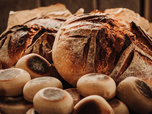 Nybakte surdeigsbrød på en trebenk